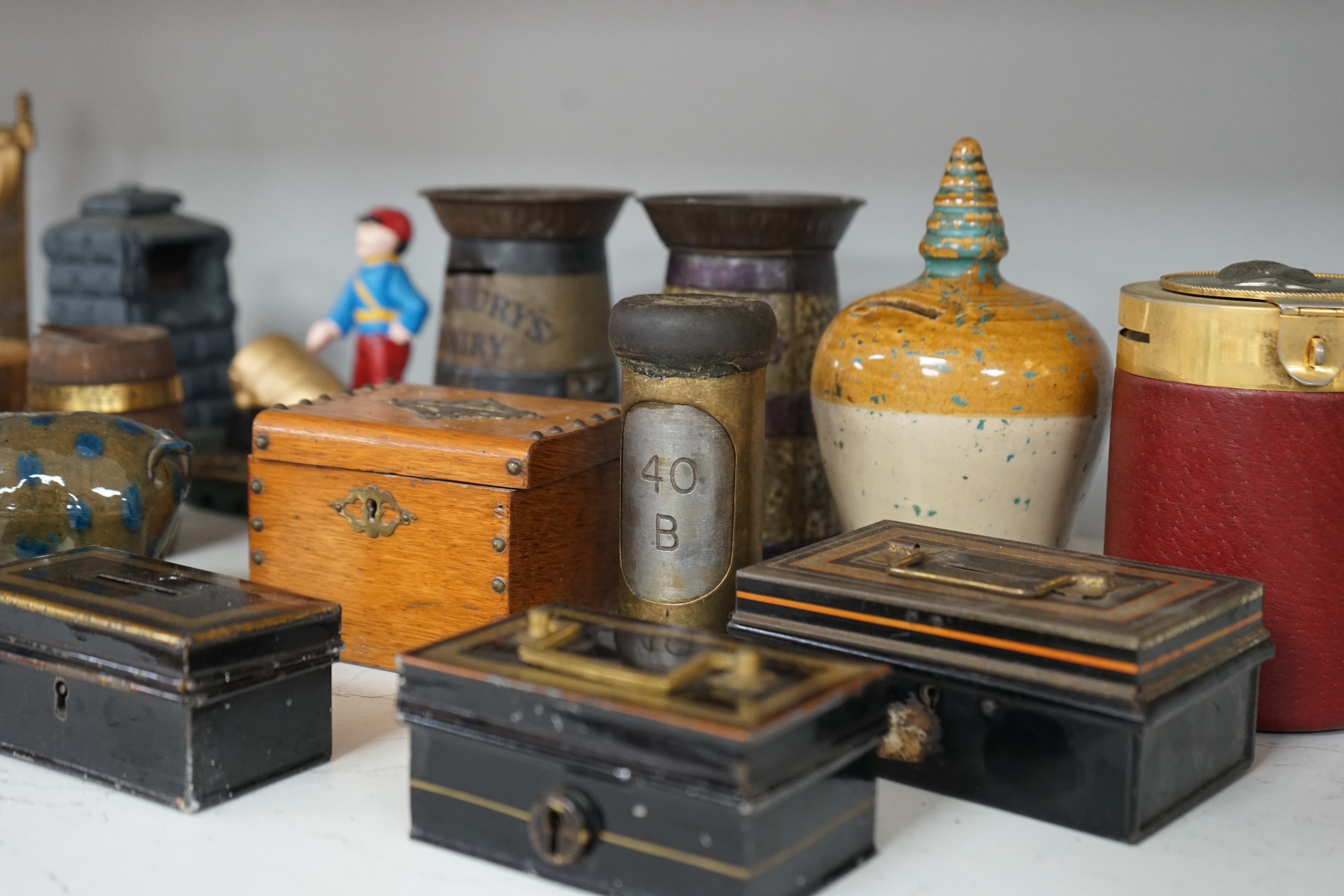 A collection of mixed tin wood and ceramic money boxes to include Cadbury’s milk chocolate, three in the form of trunks and a ceramic pig. Condition - varies